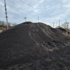 20260416_105405 - wnyDIRT.com Large mound of black coal piled outdoors with power poles and lines in the background on a cloudy day.
